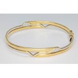 A two colour bangle, marked '750', diameter 6cm, wt. 15.2g.