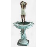 A bronze garden fountain, modelled as a woman with water