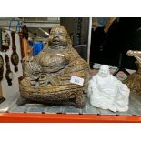 A concrete Buddha statue together with a ceramic white Buddha.