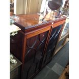 An Edwardian inlaid mahogany bookcase with glazed doors, standing on bracket feet, width 111cm.