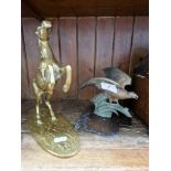A car mascot in shape of an eagle together with a brass rearing horse.