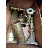 A box of brass shell cases and candlesticks.