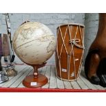 A tom tom drum and a globe on a wooden base