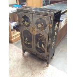 A Chinese black lacquer and mother of pearl side cabinet with applied carved stone decoration.