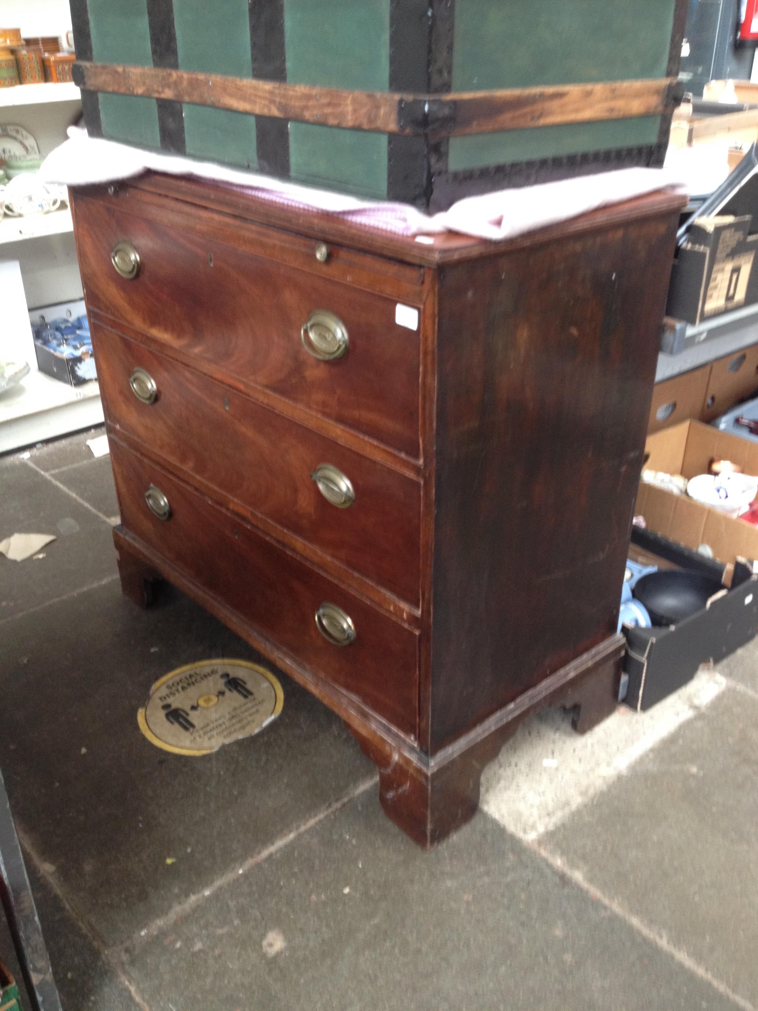 A George III mahogany chest of drawers with brushing slide, hunting scene handles, stood on