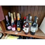 12 bottles of alcohol and an empty Bells ceramic decanter. Includes Bredon Champagne, Prosecco,