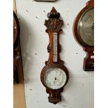 A barometer in carved oak case by Chadburns Ltd, Liverpool.