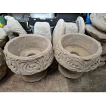 A pair of concrete garden planters with decorative pattern