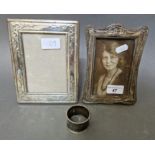 two hallmarked silver photograph frames and a hallmarked silver napkin ring.