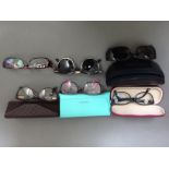 Six pairs of spectacles/sun glasses comprising Tiffany, Gucci, TEd Baker, Ray Ban and Storm.