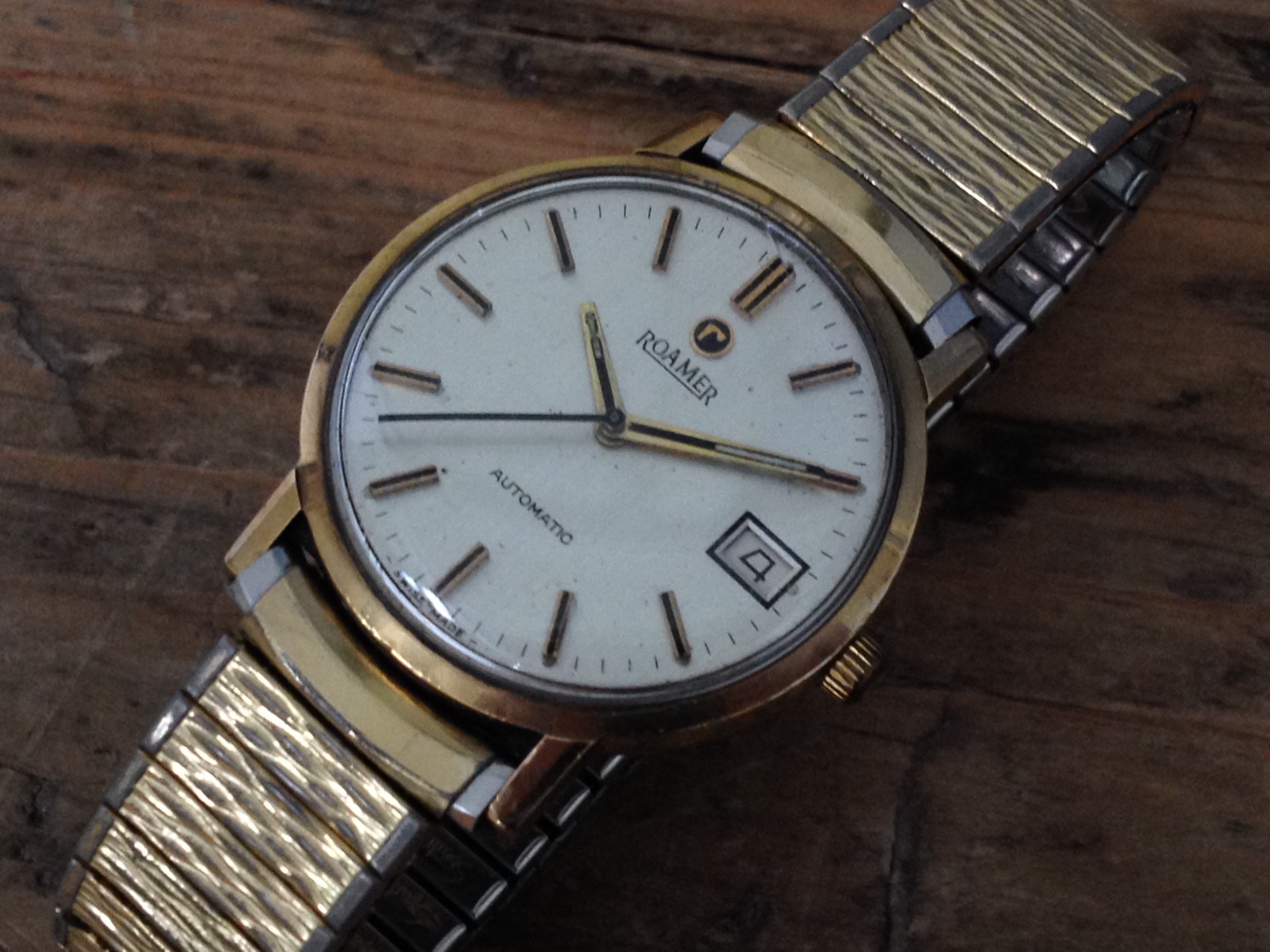 A vintage 9ct gold Roamer automatic wristwatch with gold plated flexi strap.