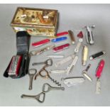 A lidded tin box containing vintage & modern penknifes, bottle openers & corkscrews to include