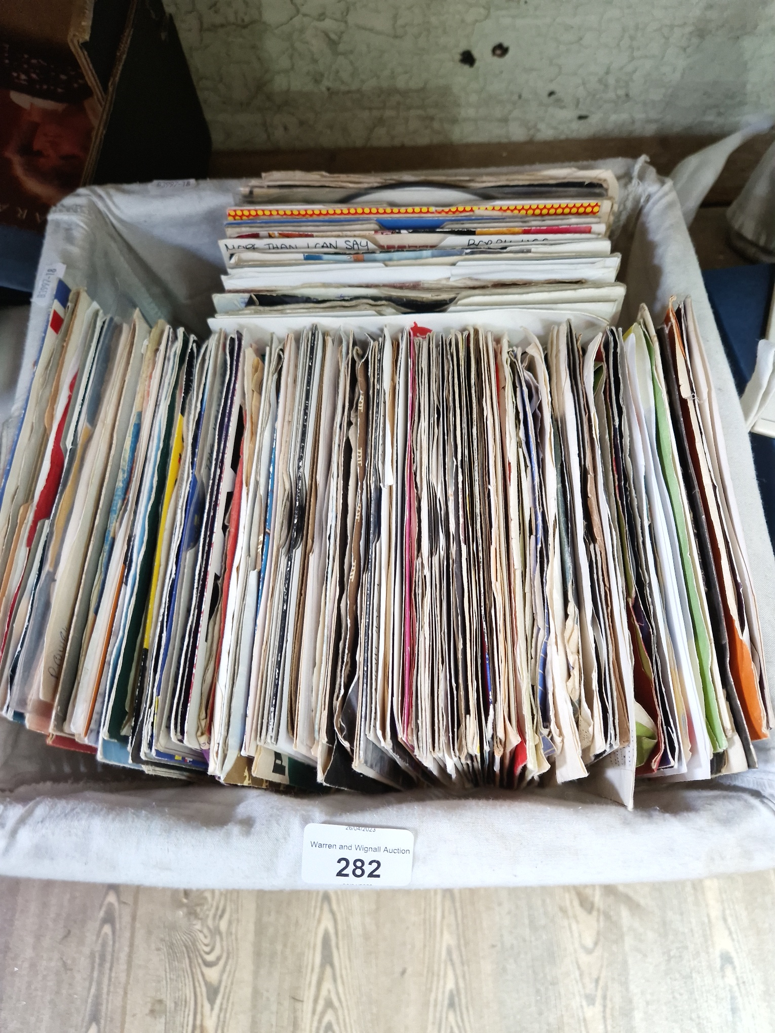 A basket of approximately 150 vinyl 7" singles, 1960s to 1990s, including The Beatles, Elvis, The