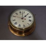 A brass bulkhead clock, diameter 26cm.