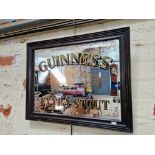 A framed Guiness extra stout advertising mirror