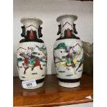 A pair of Chinese crackle glaze vases with applied lizards, decorated in colourful over enamels with