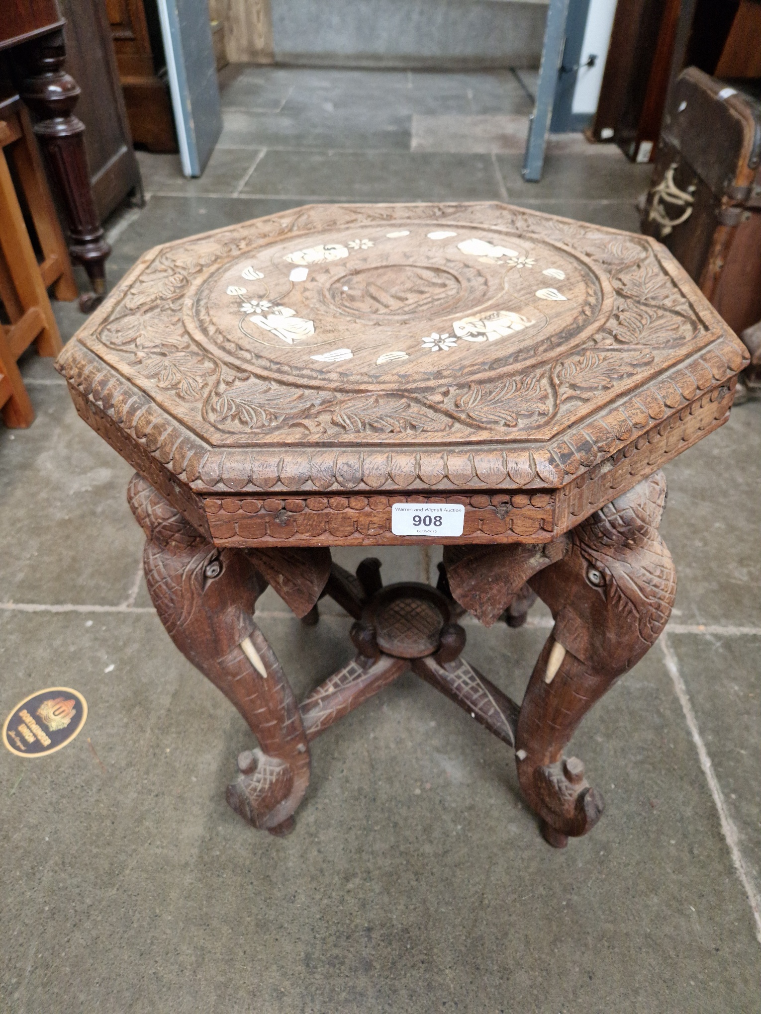 A carved wood elephant table, inlaid to top, circa 1900.