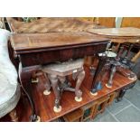 A Georgian mahogany fold top tea table on ball and claw feet.