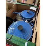 A box of blue Le Creuset pans.