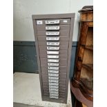 A set of grey metal filing drawers.