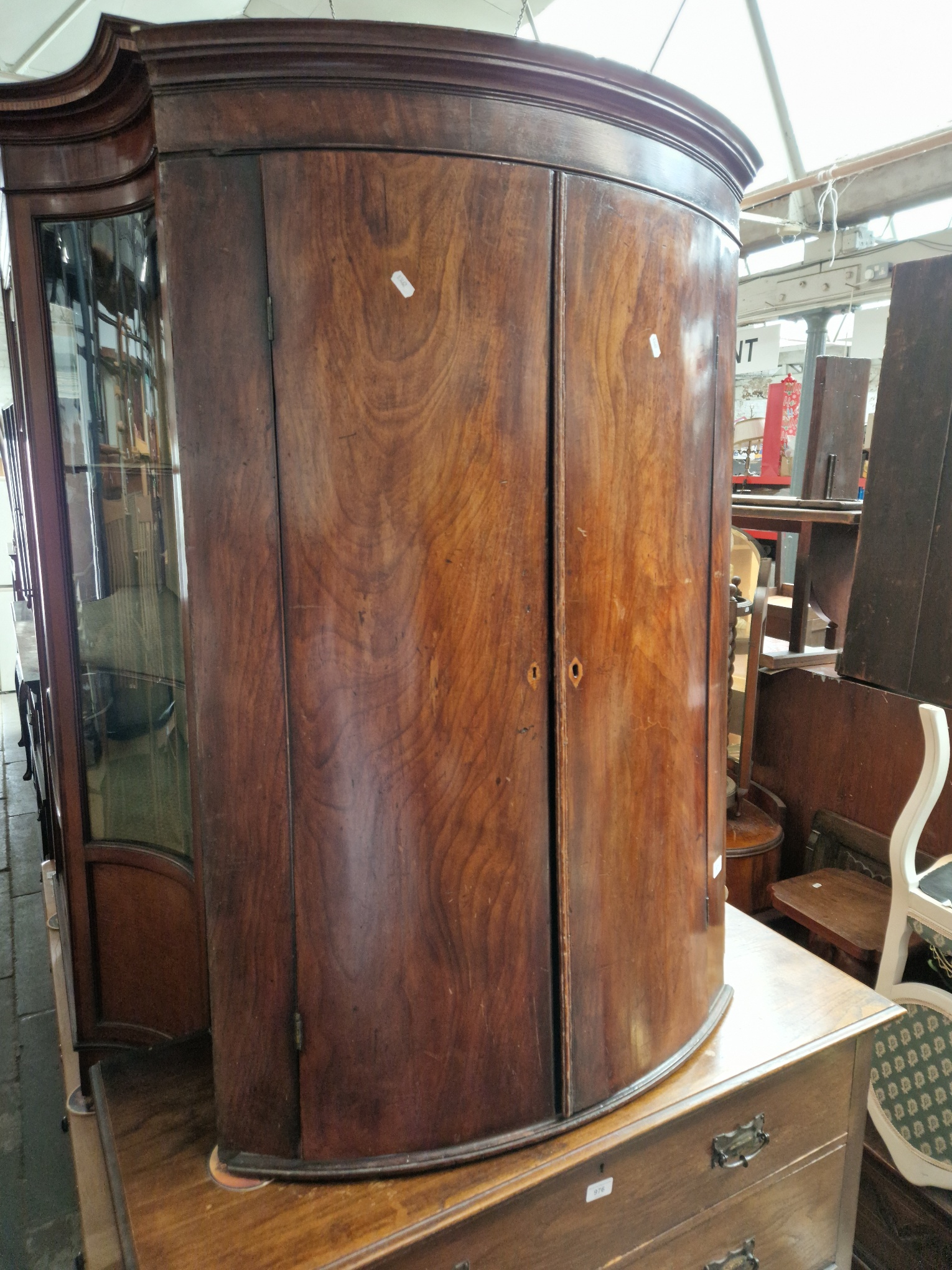 A Georgian mahogany bow front corner cabinet with stand.