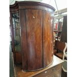 A Georgian mahogany bow front corner cabinet with stand.