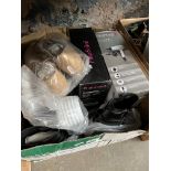 A box of various unworn shoes and two unused hair dryers.