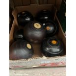 A box containing 3 sets of crown green bowls and 2 jacks