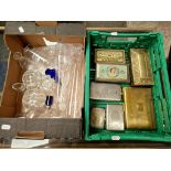 A box of glassware and a box of metal cigarette boxes and tins.