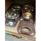 Four carved wooden masks, two Indonesian, two African.