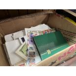 A box of stamp covers and loose stamps