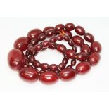 A marbled cherry bakelite graduated bead necklace, the oval shaped beads ranging in length from