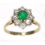 An emerald and diamond cluster ring, the central pear cut stone weighing approx. 0.50cts,