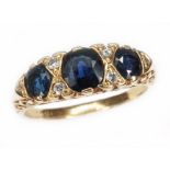A sapphire and diamond ring, the central stone measuring approx. 5.06mm x 5.20mm x 2.86mm, scroll