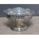 An Edwardian silver pedestal dish, pierced rim above bowl with embossed panels, domed foot, John