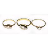 Three diamond rings; two three stone illusion set diamond rings and a single stone diamond ring, two
