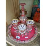 A Bohemian part drinking set, 19th century, comprised of a large circular tray, a decanter, two cups