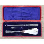 A cased hallmarked silver handle button hook and shoe horn set.