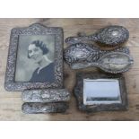 Hallmarked silver comprising a photograph frame, a mirror, silver backed brushes and a hand