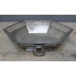 A George V hexagonal silver dish with piecred border and two loop swing handles, Martin Hall & Co