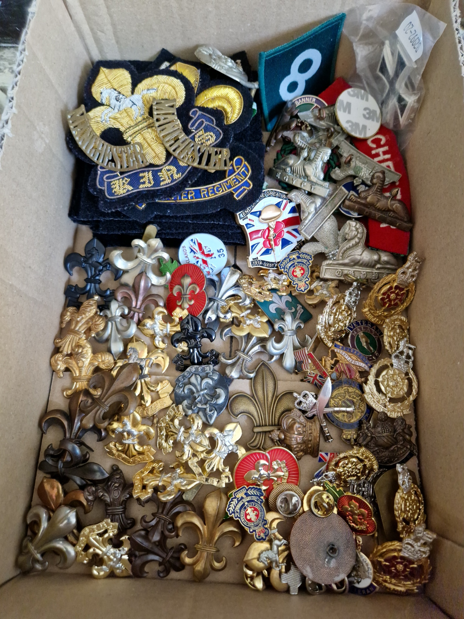 A collection of cap badges and other related items including WW1 and WW2 examples, patches, etc,