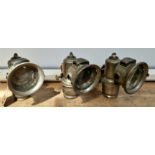 Three vintage Lucas 'Calcia Club' carbide bicycle lamps, one complete, one with cracked glass and