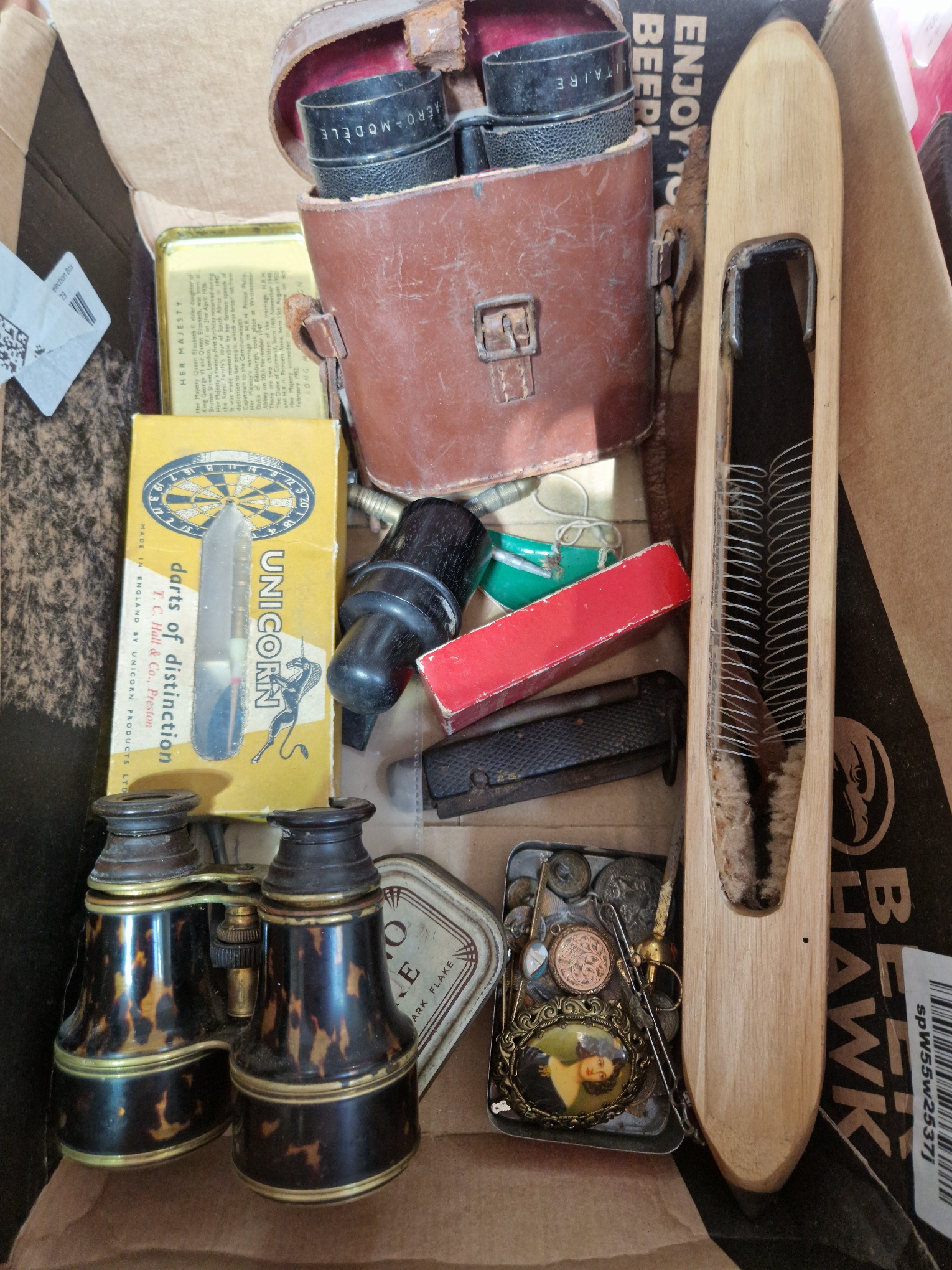 A box of collectables including two pairs of vintage binoculars, a vintage flying shuttle, darts,