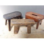 A group of three miniature antique stools.