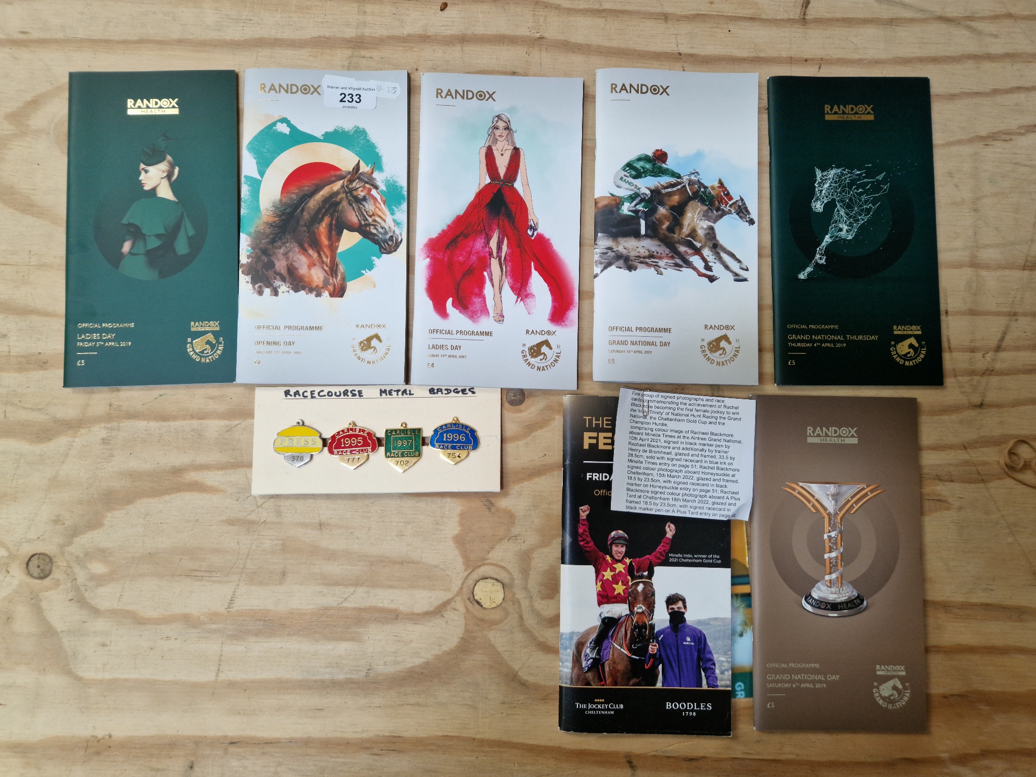 A collection of Grand National meeting race cards, 2019 & 2023 and metal badges from Carlisle