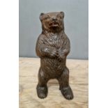 A cast metal money box in shape of a bear.