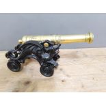 A reproduction cast metal and brass table cannon, length 44cm.