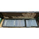 A tin containing a collection of old glass photographic magic lantern slides, mostly travel,