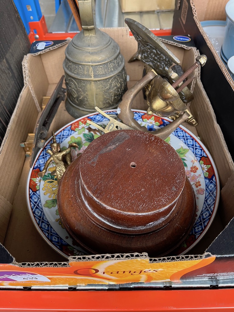 A box of metalware including a brass door knocker, a bell, etc.