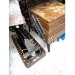 A Singer sewing machine and a cantilever vintage sewing box.